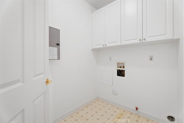 clothes washing area with hookup for a washing machine, light floors, baseboards, cabinet space, and hookup for a gas dryer