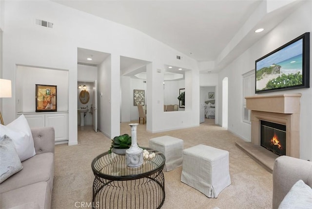 living area featuring recessed lighting, visible vents, light colored carpet, and a premium fireplace