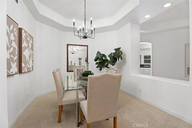 dining room featuring a raised ceiling, recessed lighting, an inviting chandelier, carpet flooring, and baseboards