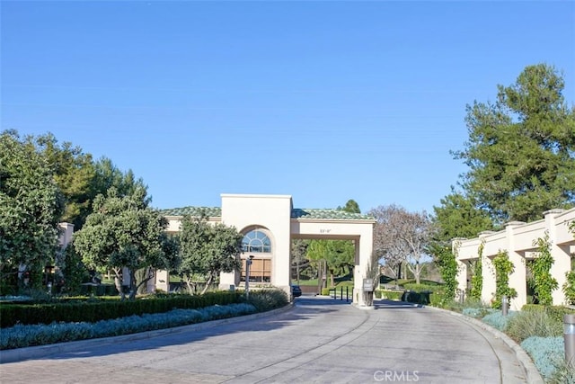 view of road with a gated entry, curbs, and a gate