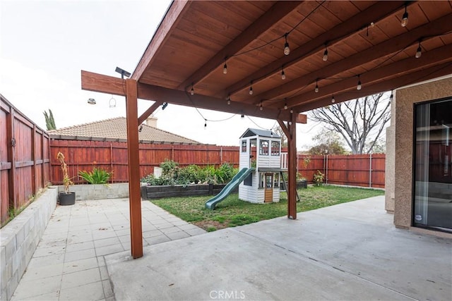 view of patio with a playground and a fenced backyard