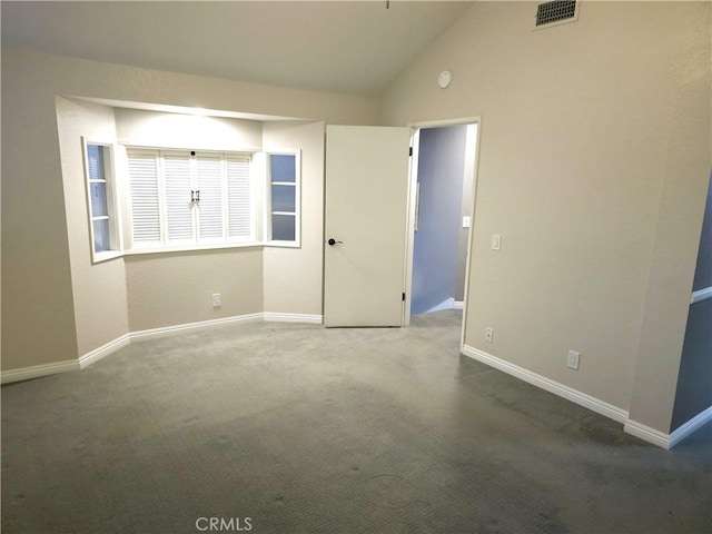 carpeted empty room featuring visible vents, baseboards, and lofted ceiling