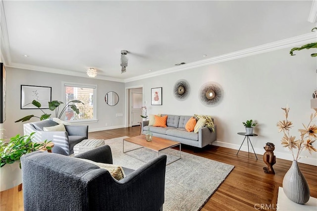 living area featuring visible vents, crown molding, baseboards, and wood finished floors