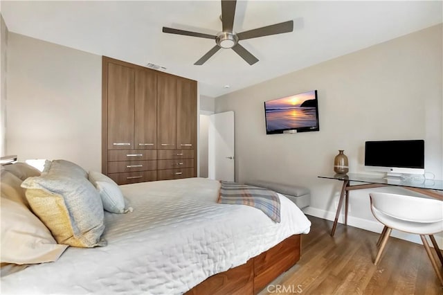 bedroom with visible vents, a ceiling fan, baseboards, and wood finished floors