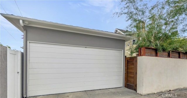 detached garage featuring fence