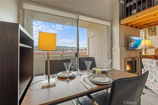 dining room featuring a warm lit fireplace