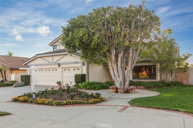 view of front facade with concrete driveway, a garage, and stucco siding