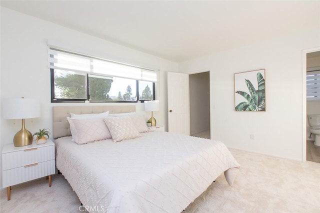 carpeted bedroom featuring ensuite bath