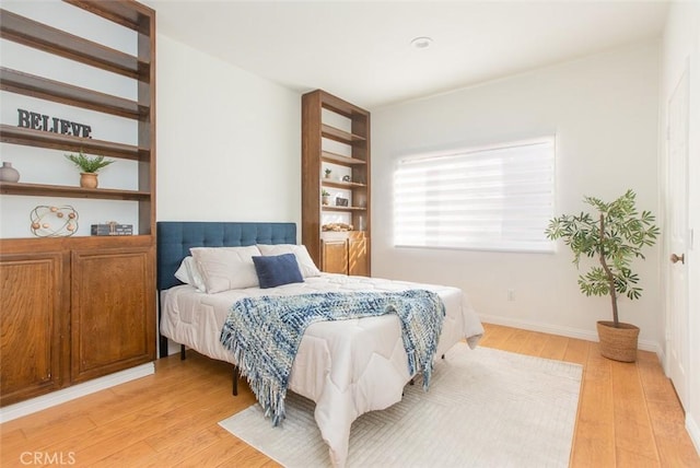 bedroom with light wood finished floors and baseboards