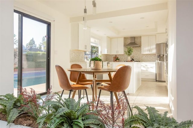 dining room with light tile patterned flooring and a raised ceiling