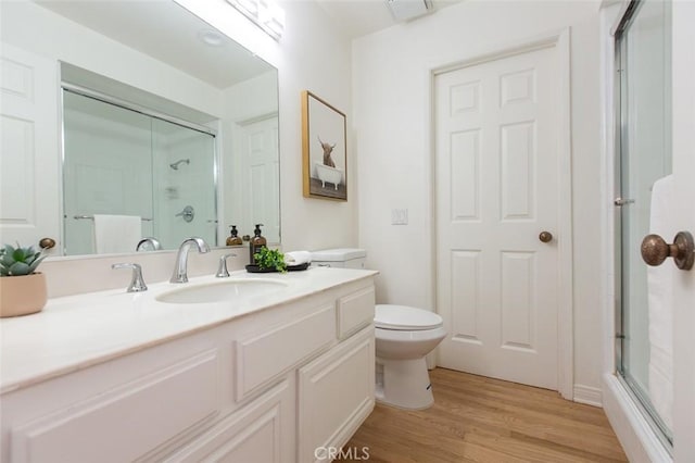 full bath with visible vents, toilet, wood finished floors, an enclosed shower, and vanity