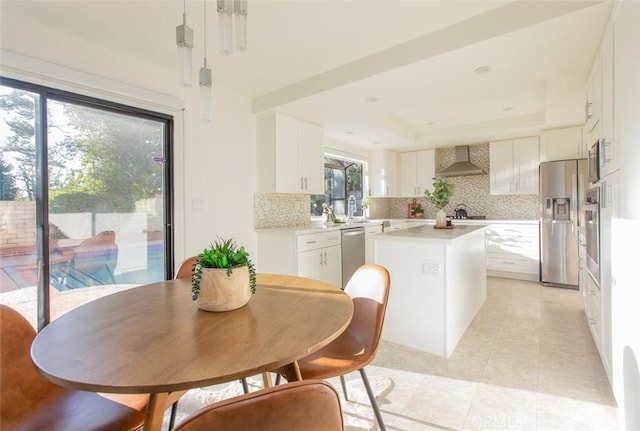 dining space featuring a raised ceiling and light tile patterned floors