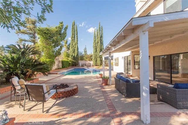 pool featuring a patio area and an outdoor living space with a fire pit