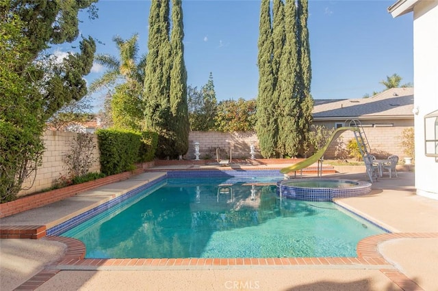 view of pool featuring a patio area, a pool with connected hot tub, and a fenced backyard