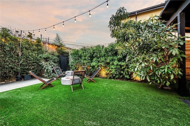 view of yard featuring an outdoor fire pit and fence