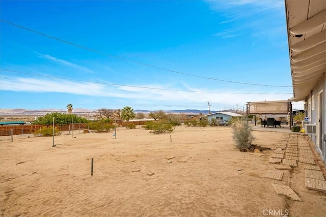 view of yard featuring a mountain view and fence