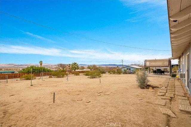 view of yard with a mountain view, fence, and a patio area