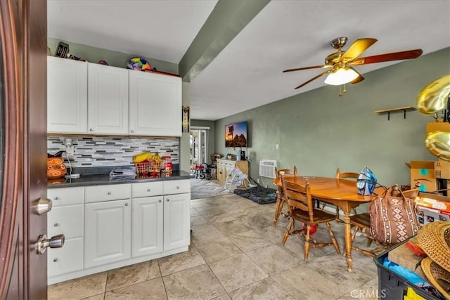 kitchen featuring dark countertops, decorative backsplash, white cabinets, and a wall mounted AC