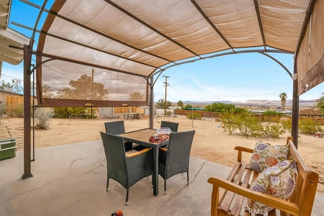 view of patio with outdoor dining space and fence