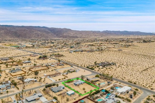 birds eye view of property featuring a mountain view, a rural view, and view of desert