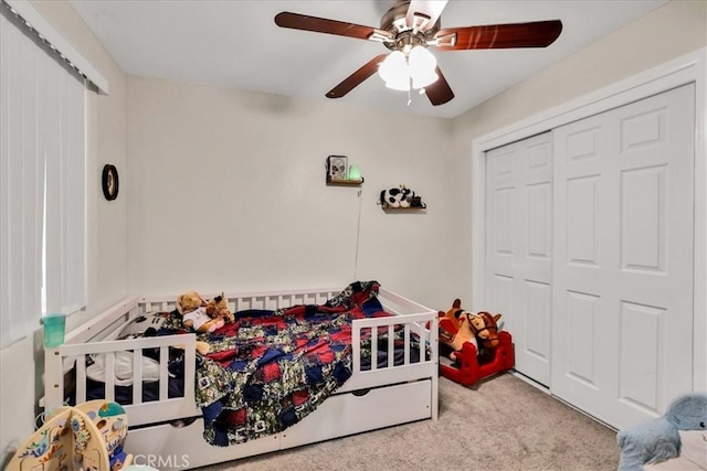 carpeted bedroom featuring a closet and a ceiling fan