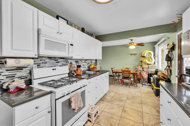 kitchen with decorative backsplash, white appliances, white cabinets, and dark countertops