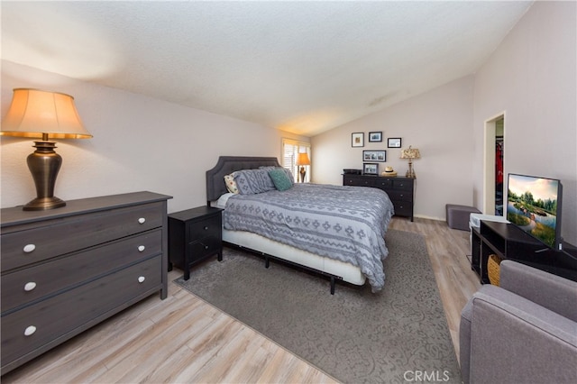 bedroom with lofted ceiling and light wood-style flooring