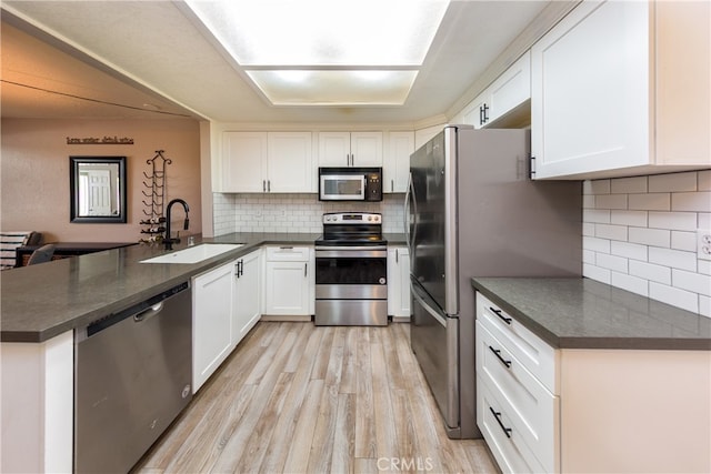 23212 Kimmore Ter, Valencia, CA 91355 - kitchen with a sink, light wood-style flooring, appliances with stainless steel finishes, and dark countertops