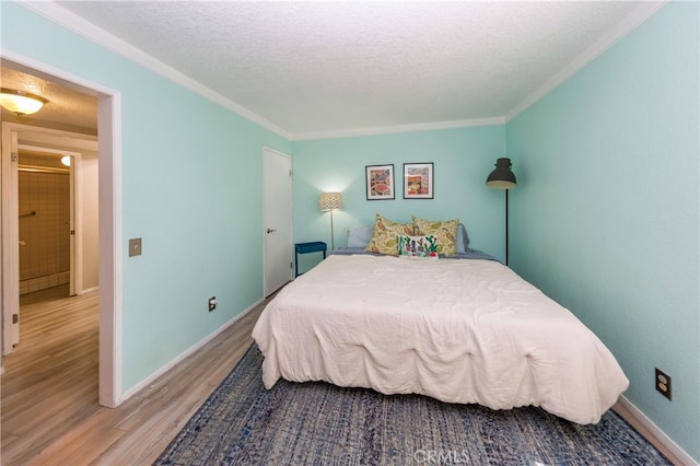 23212 Kimmore Ter, Valencia, CA 91355 - bedroom featuring crown molding, a textured ceiling, baseboards, and wood finished floors