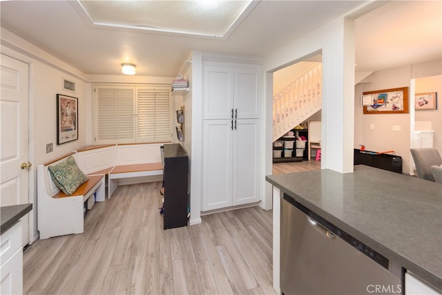 kitchen with dark countertops, white cabinets, light wood-style flooring, and visible vents