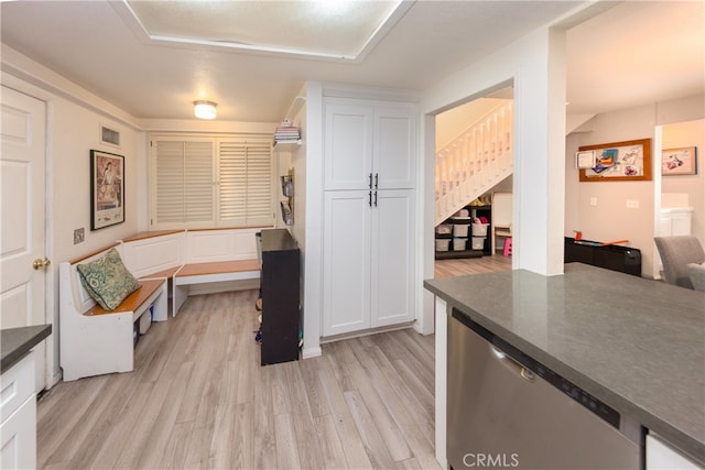 23212 Kimmore Ter, Valencia, CA 91355 - kitchen featuring stainless steel dishwasher, visible vents, dark countertops, white cabinetry, and light wood-style flooring