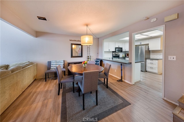 23212 Kimmore Ter, Valencia, CA 91355 - dining area with visible vents and light wood-style floors