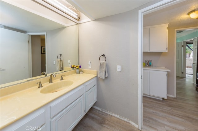 bathroom featuring vanity, baseboards, and wood finished floors