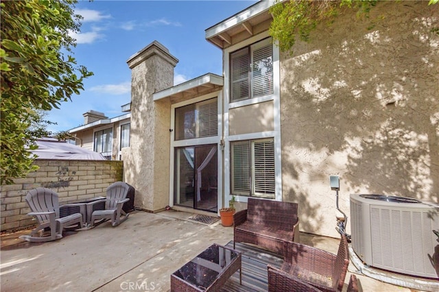 back of house featuring stucco siding, central air condition unit, and a patio