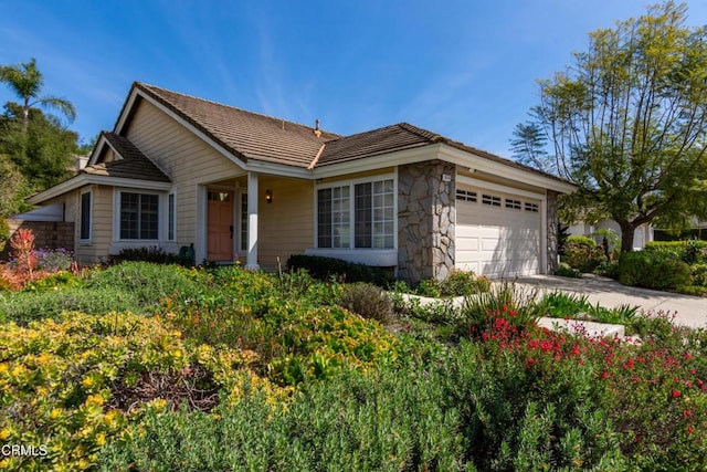 single story home featuring an attached garage, stone siding, and driveway