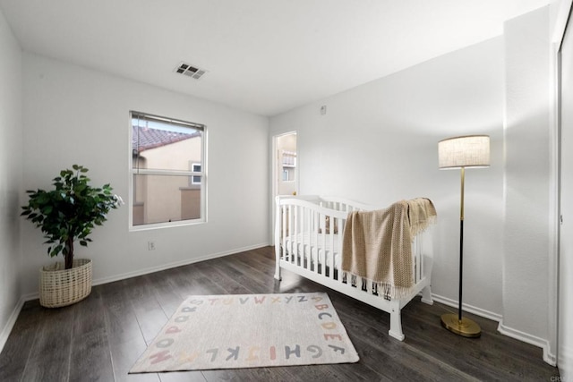 bedroom with visible vents, baseboards, and wood finished floors