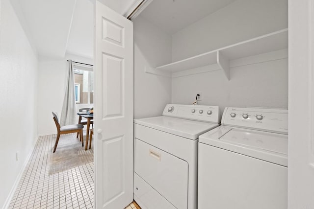 laundry area with washer and dryer, baseboards, light tile patterned flooring, and laundry area