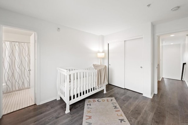 unfurnished bedroom featuring wood finished floors, a closet, and baseboards