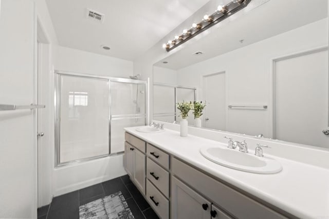 bathroom featuring tile patterned flooring, visible vents, double vanity, and a sink