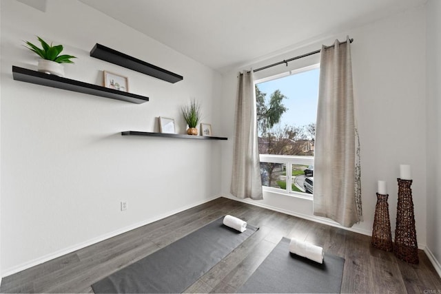 workout room featuring baseboards and wood finished floors