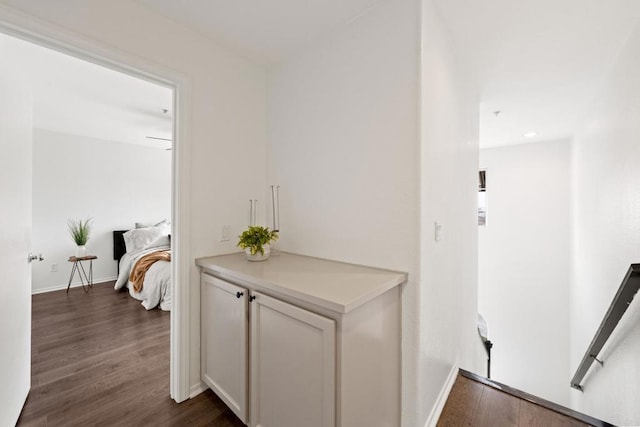 hallway with recessed lighting, baseboards, and dark wood-style floors