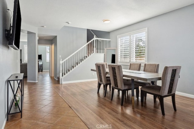 tiled dining space with stairway and baseboards