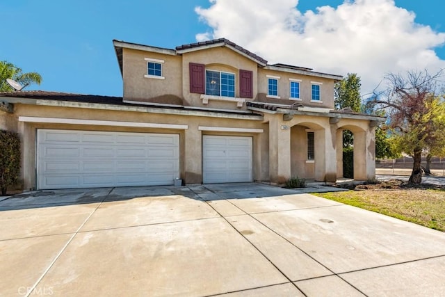 traditional-style house featuring an attached garage, driveway, and stucco siding