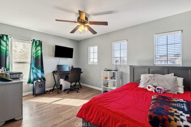 bedroom featuring a ceiling fan, baseboards, and wood finished floors