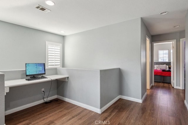 unfurnished office featuring visible vents, baseboards, recessed lighting, wood finished floors, and built in study area