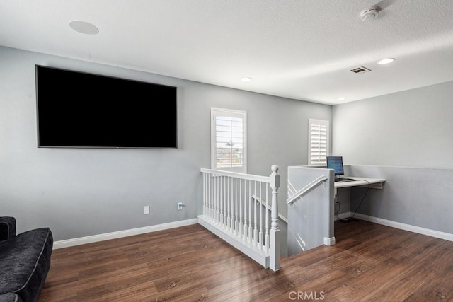 bedroom with visible vents, wood finished floors, baseboards, and a textured ceiling