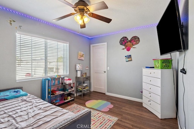 bedroom with ceiling fan, baseboards, and wood finished floors