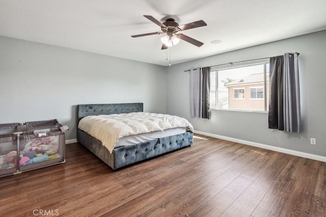 bedroom featuring a ceiling fan, wood finished floors, and baseboards