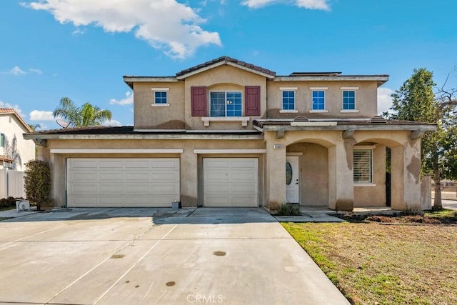 view of front of property with stucco siding, an attached garage, and driveway