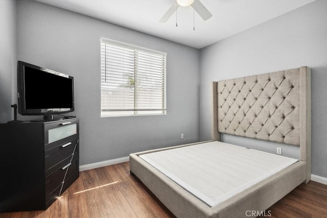 bedroom featuring a ceiling fan, baseboards, and wood finished floors